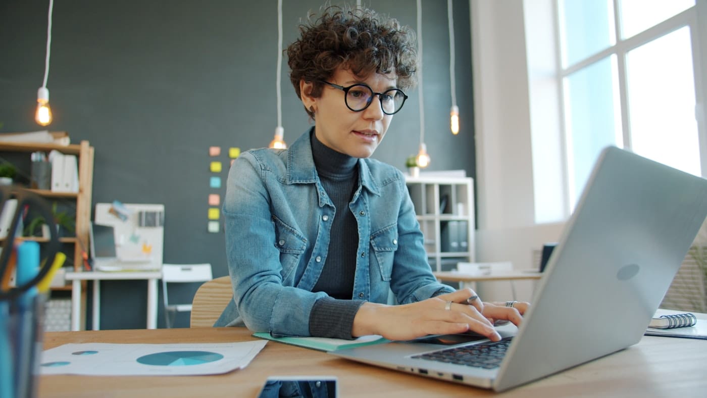 Person reviewing personal and business lending options on a laptop in a modern office — Stearn Lending